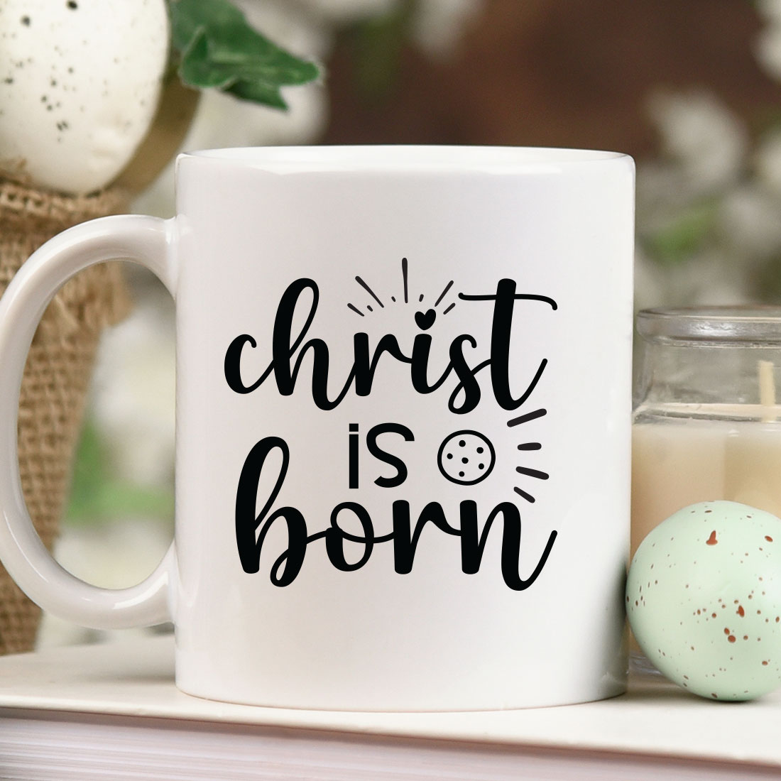 White coffee mug sitting on top of a table next to a candle.