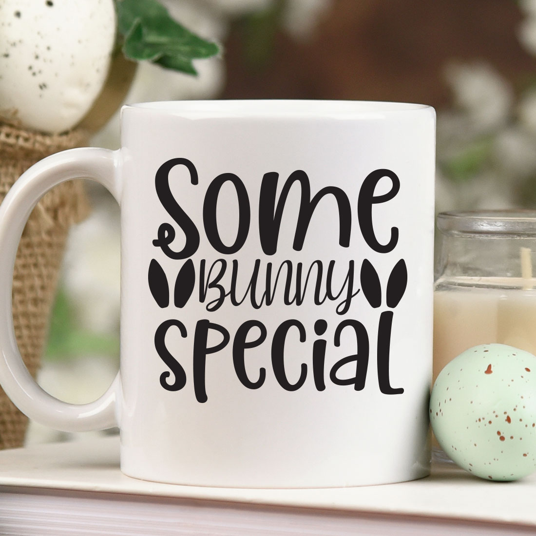 White coffee mug sitting on top of a table next to a candle.