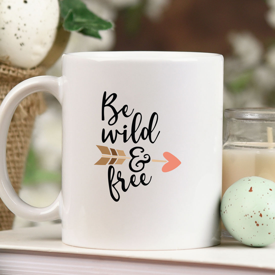 White coffee mug sitting on top of a table next to a candle.