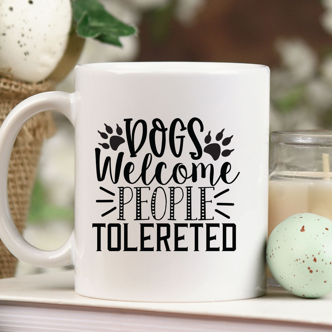 Coffee mug sitting on top of a table next to a candle.