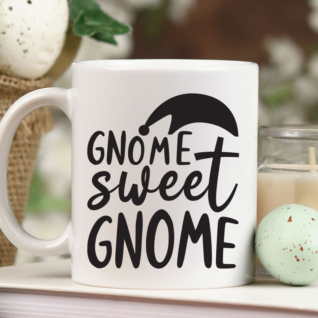 White coffee mug sitting on top of a table next to a candle.