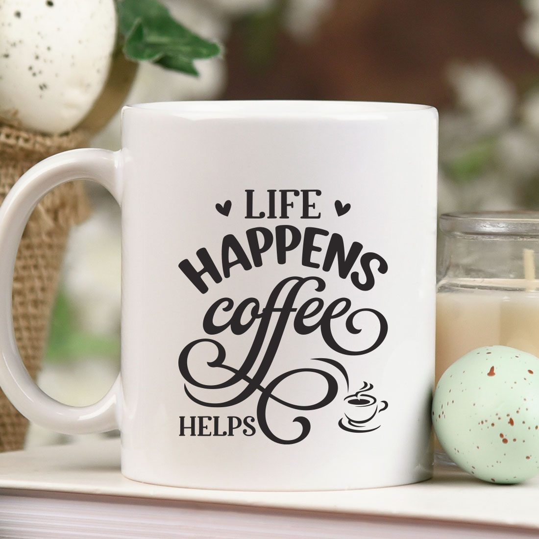 White coffee mug sitting on top of a table next to a candle.