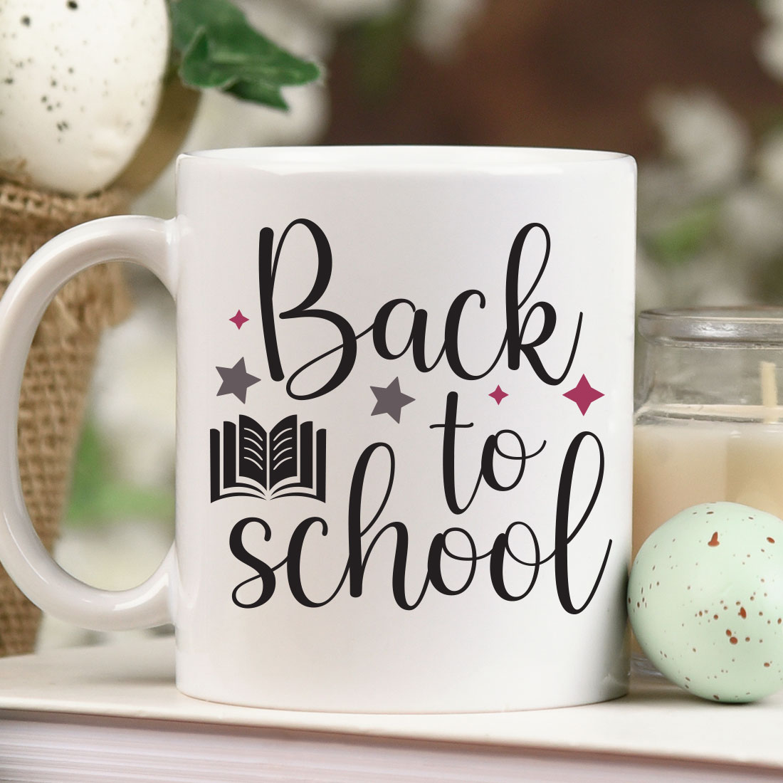 Coffee mug that says back to school next to a candle.