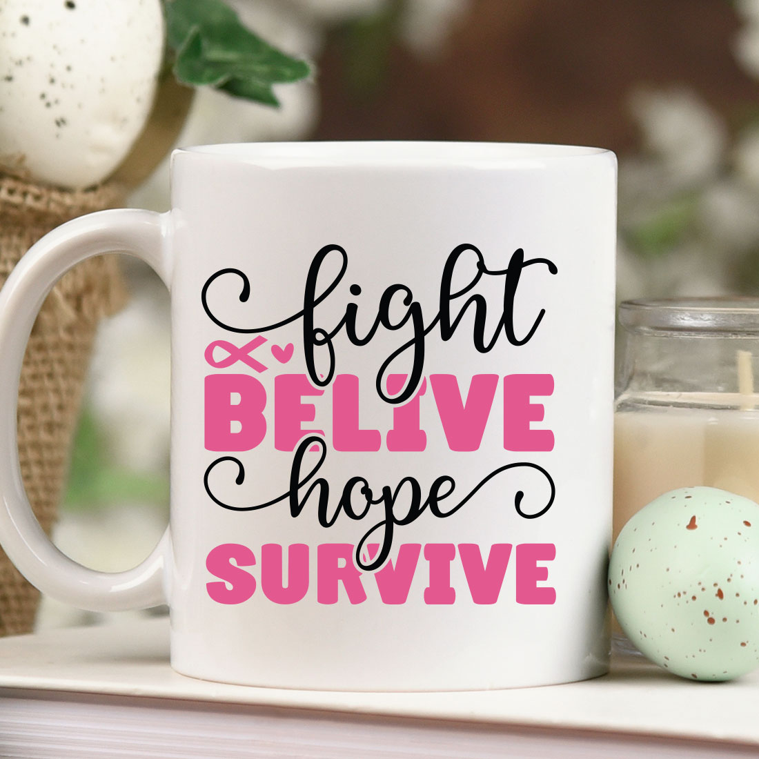 Coffee mug that says fight and believe hope survive next to a candle.