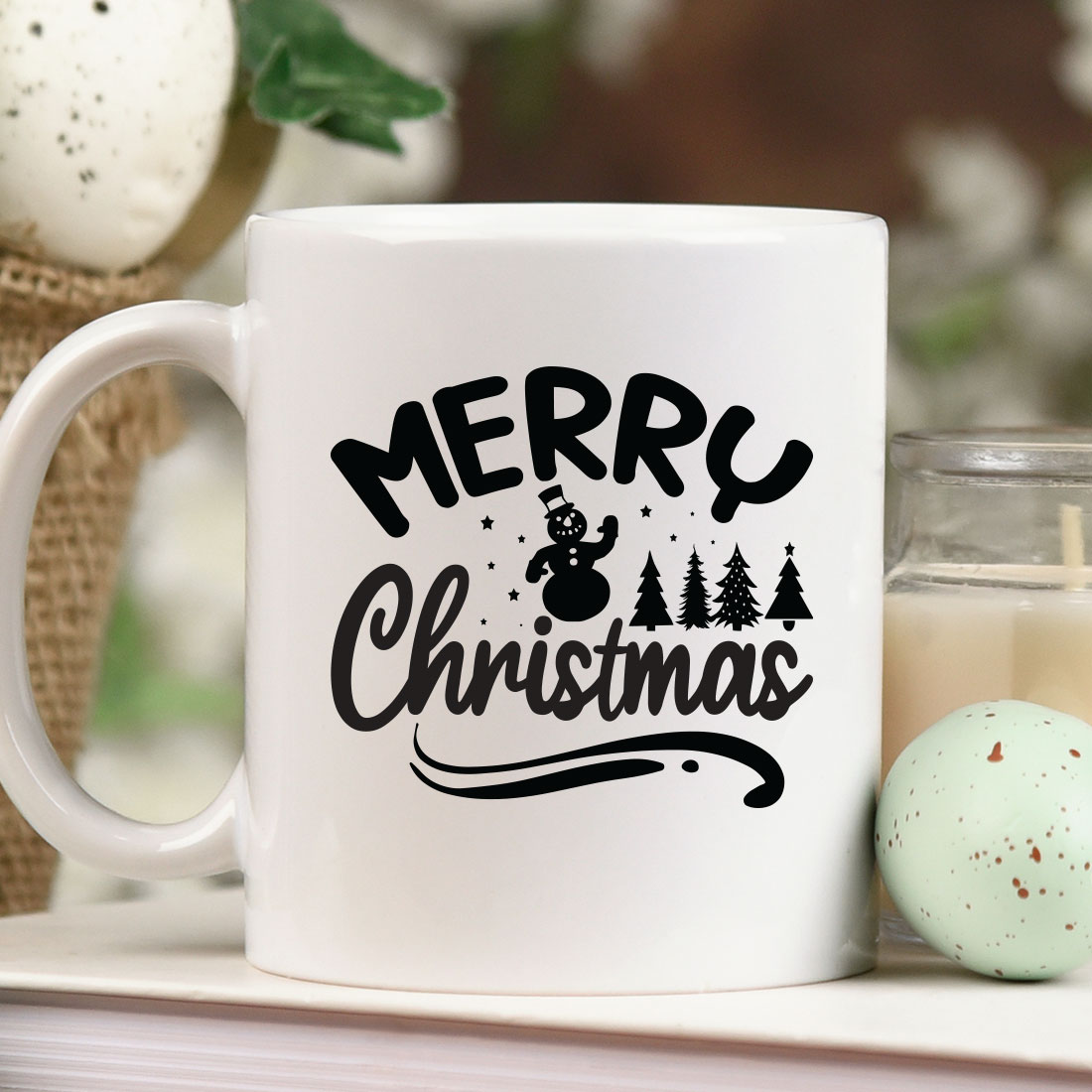 White coffee mug sitting on top of a table next to a candle.