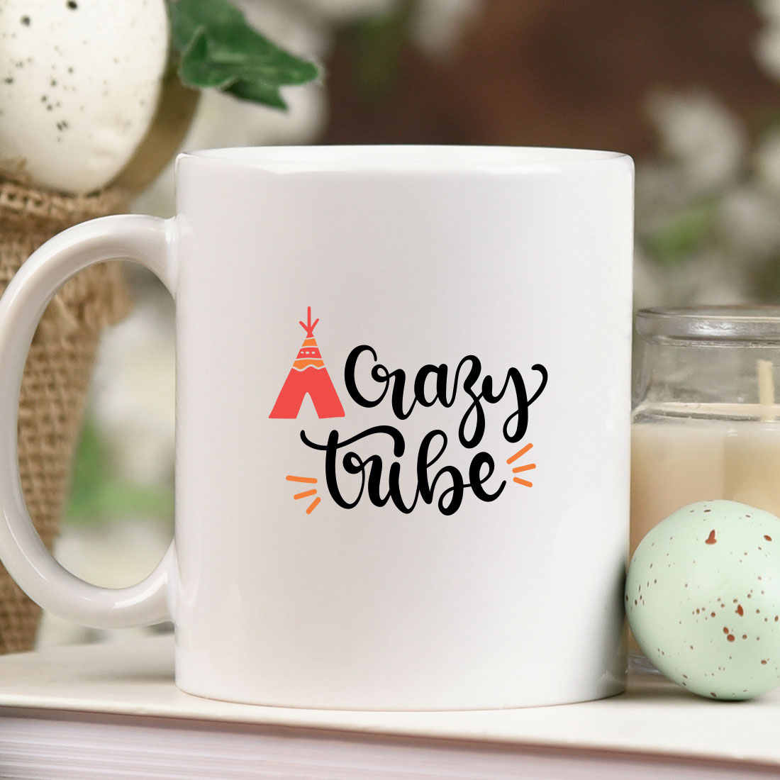 White coffee mug sitting on top of a table next to a candle.