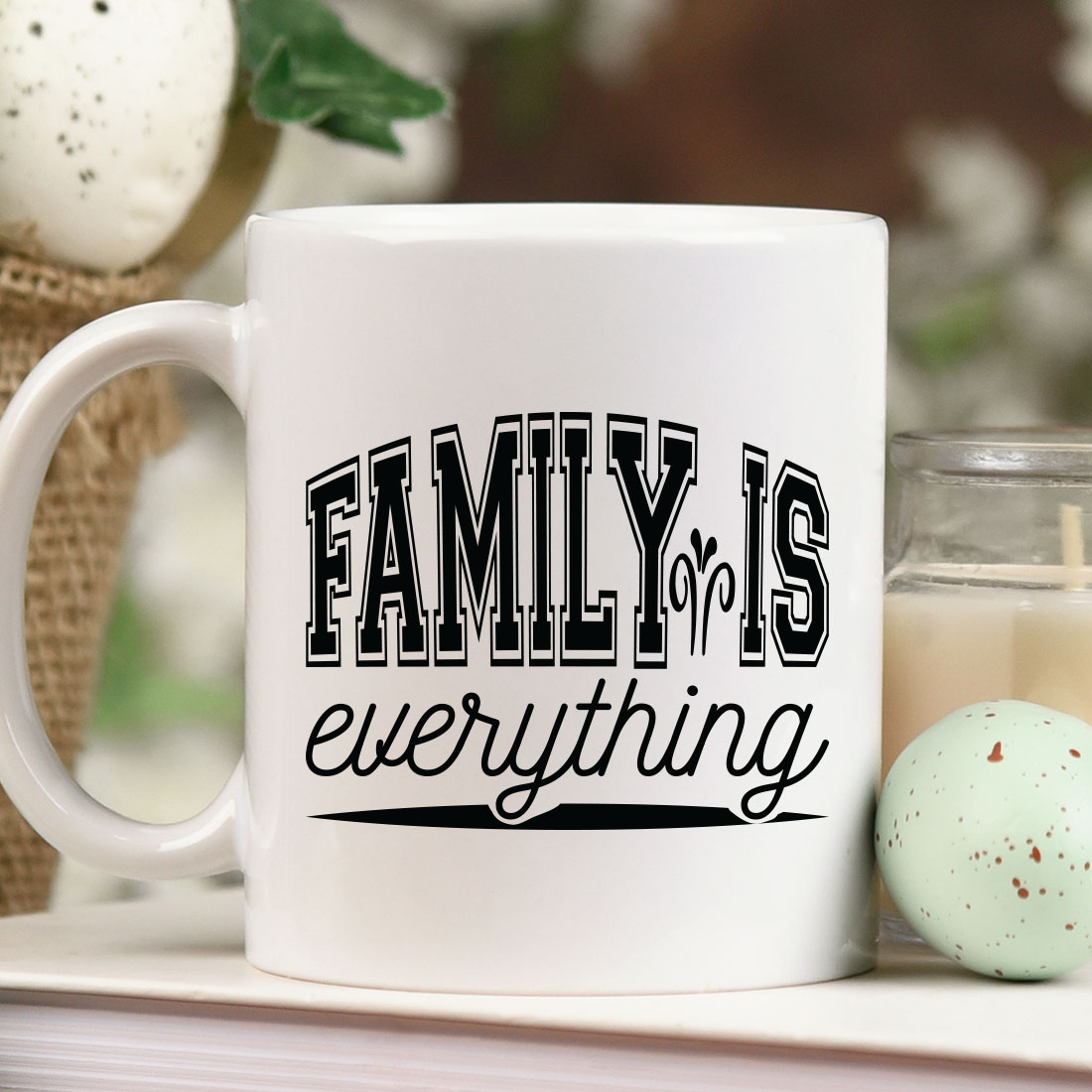 White coffee mug sitting on top of a table next to a candle.