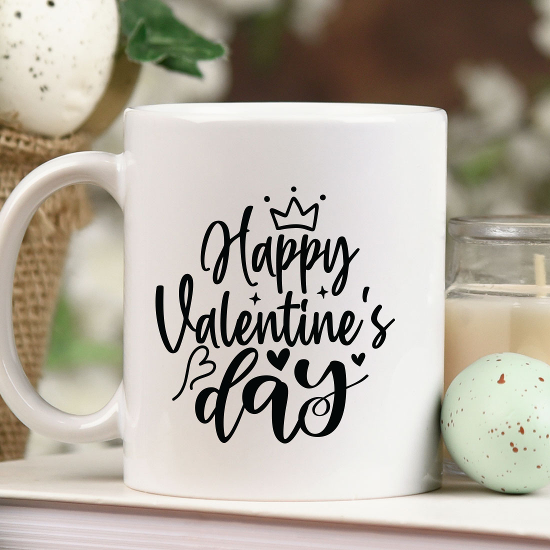 White coffee mug sitting on top of a table next to a candle.