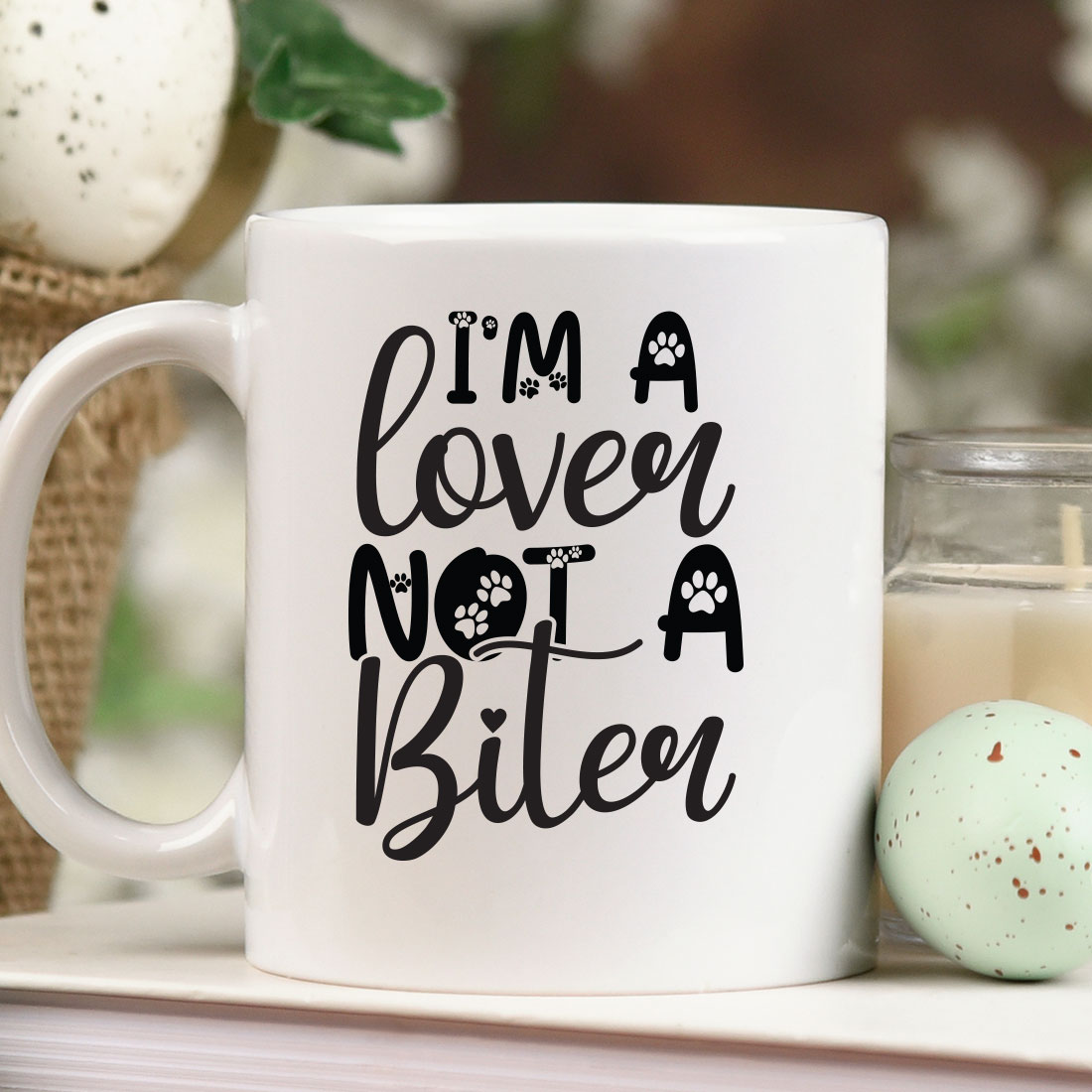 White coffee mug sitting on top of a table next to a candle.