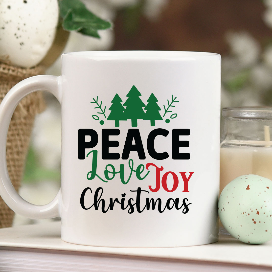 Coffee mug sitting on top of a table next to a candle.