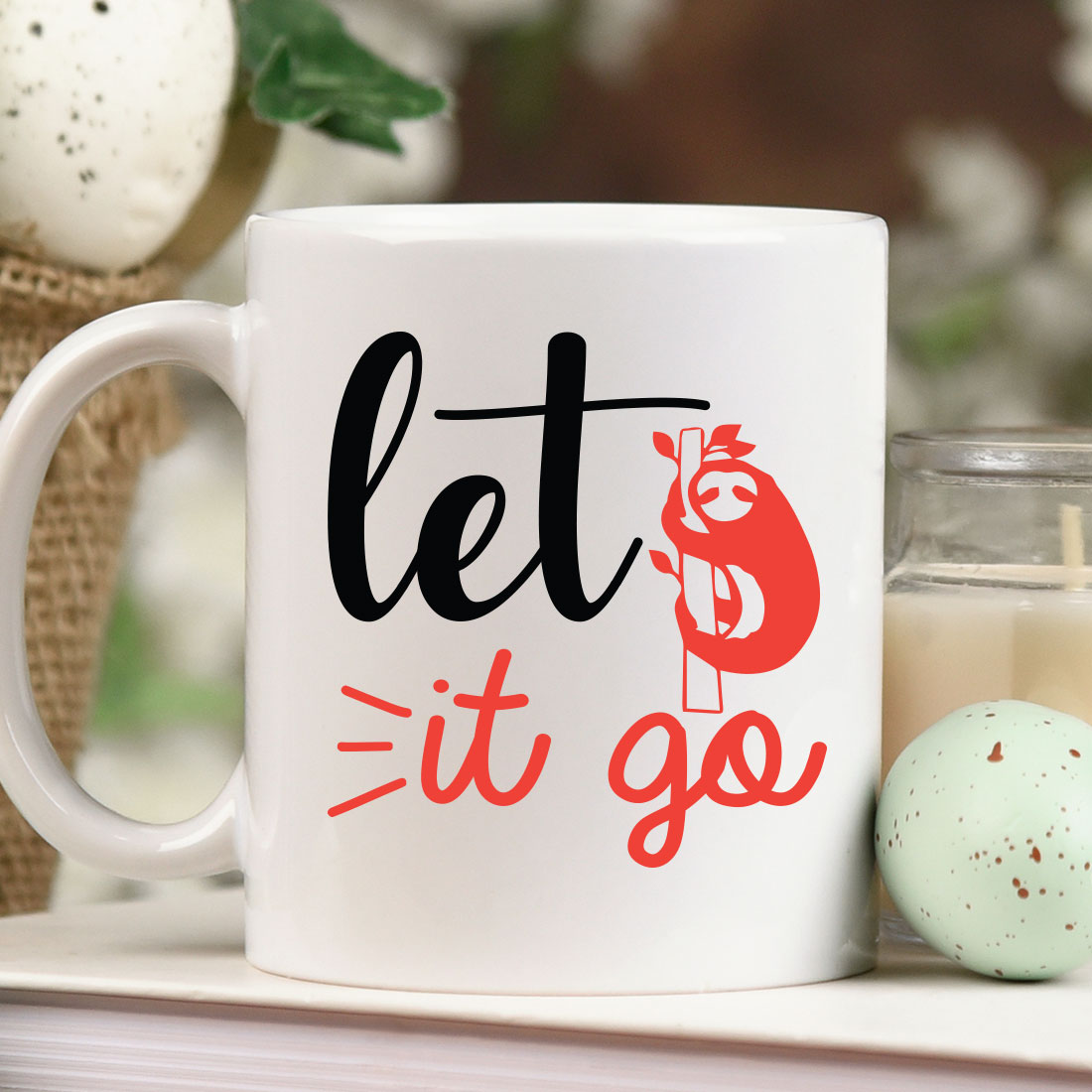 Coffee mug that says let it go next to a candle.