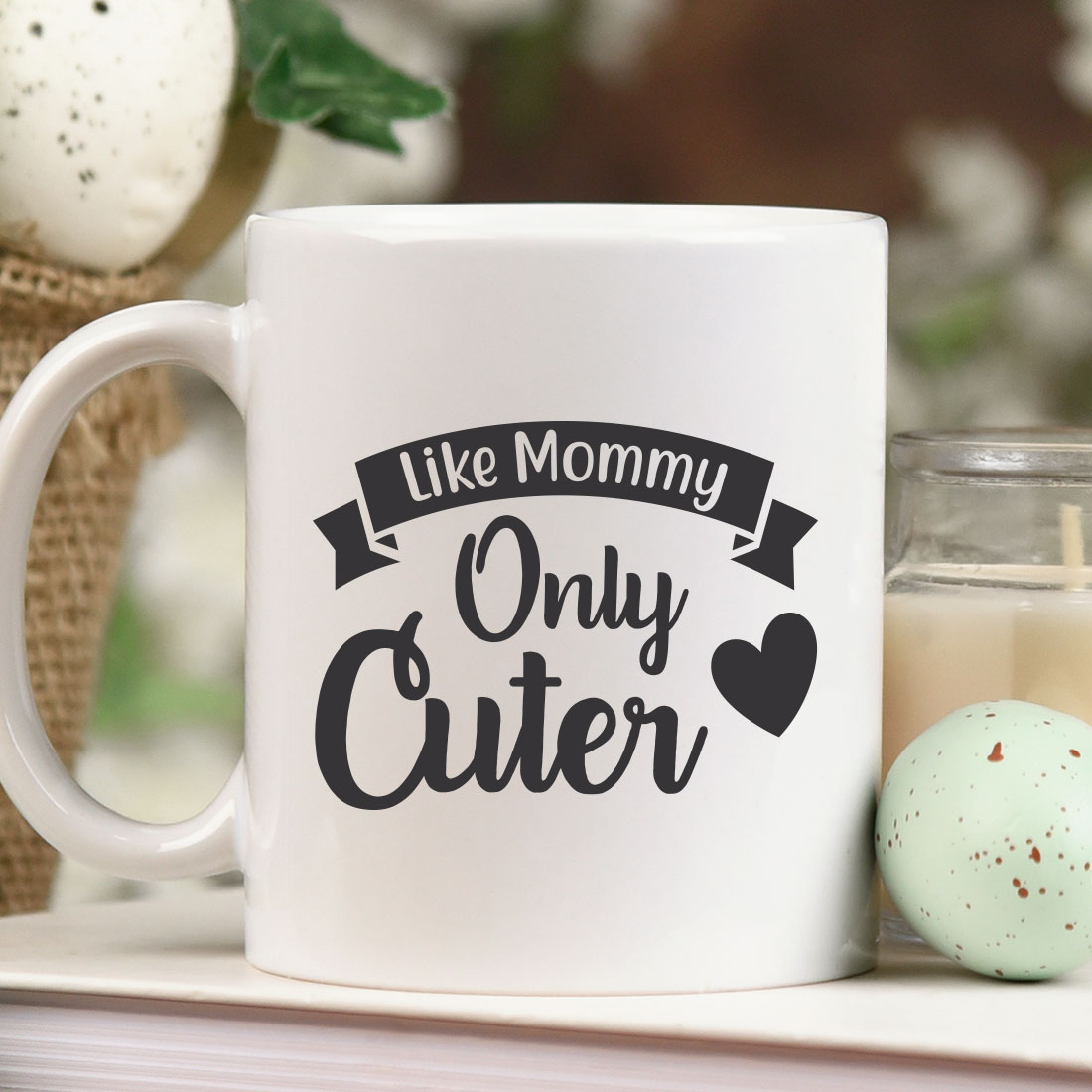 White coffee mug sitting on top of a table next to a candle.