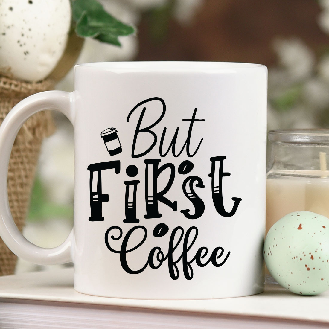 White coffee mug sitting on top of a table next to a candle.