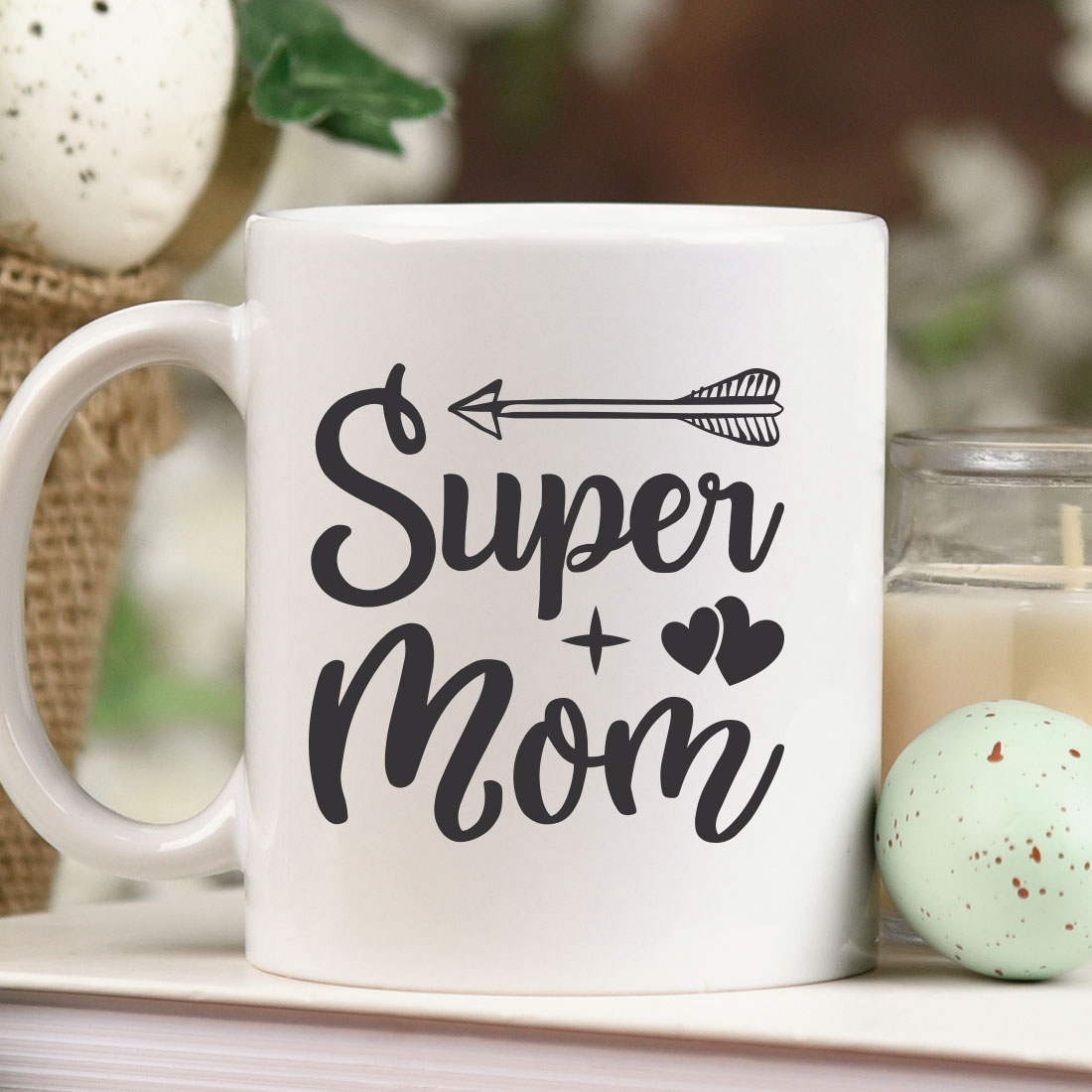 White coffee mug sitting on top of a table next to a candle.