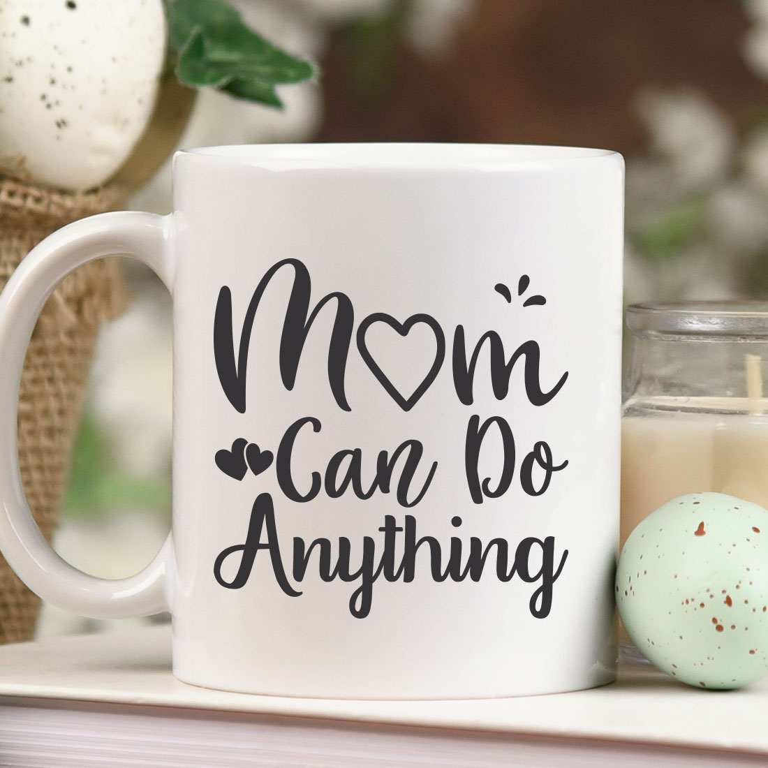 Coffee mug sitting on a shelf next to a candle.