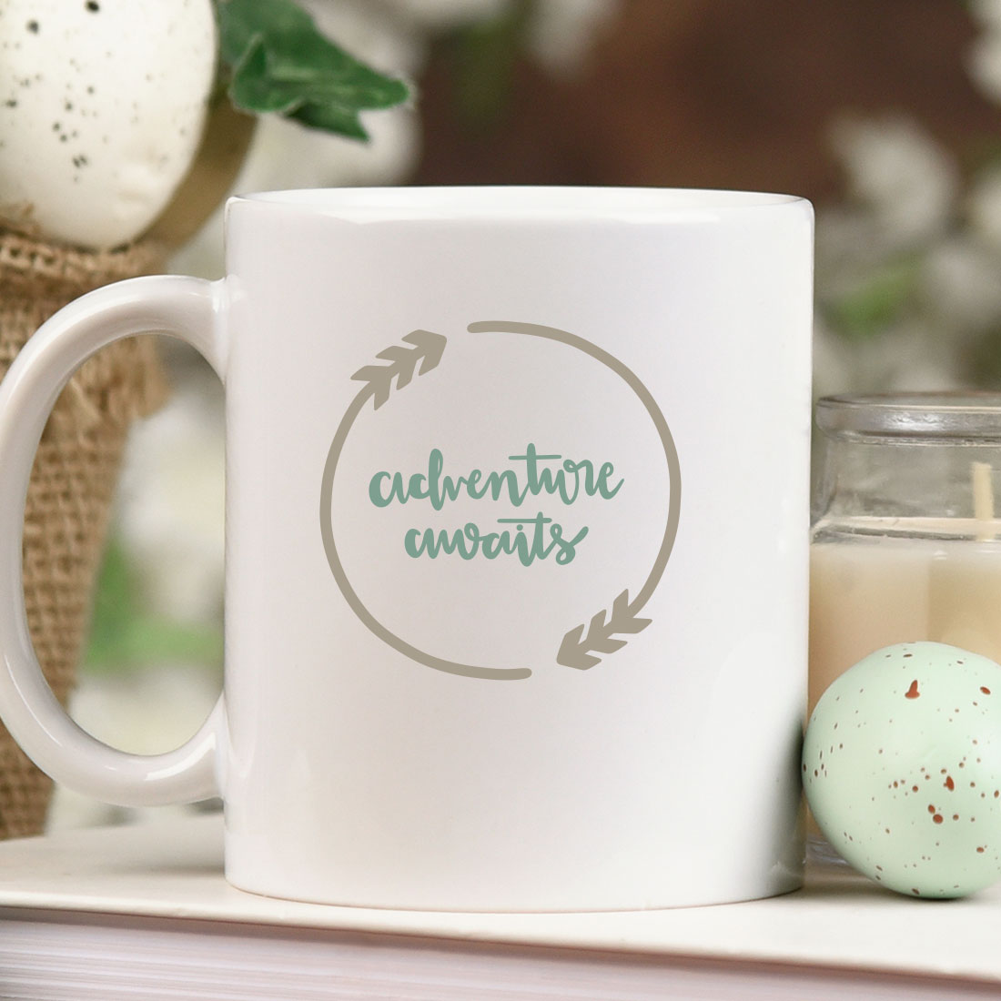 White coffee mug sitting on top of a table next to a candle.