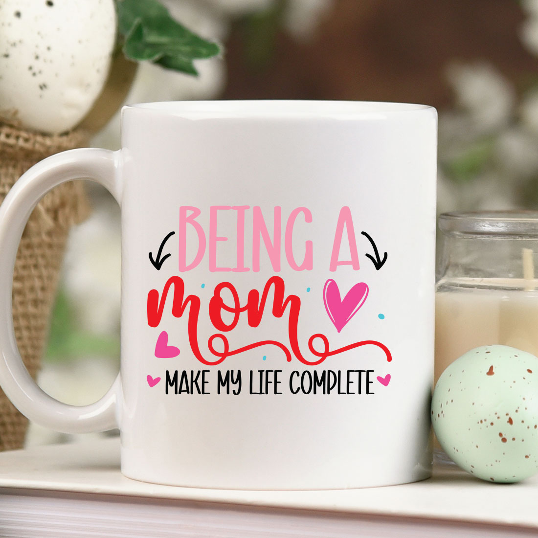 Coffee mug sitting on top of a table next to a candle.