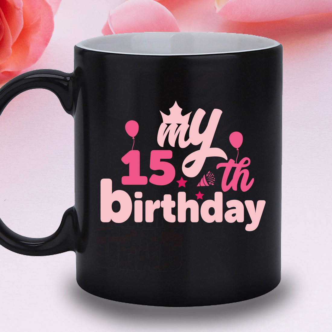 Black coffee mug with a pink design on it.