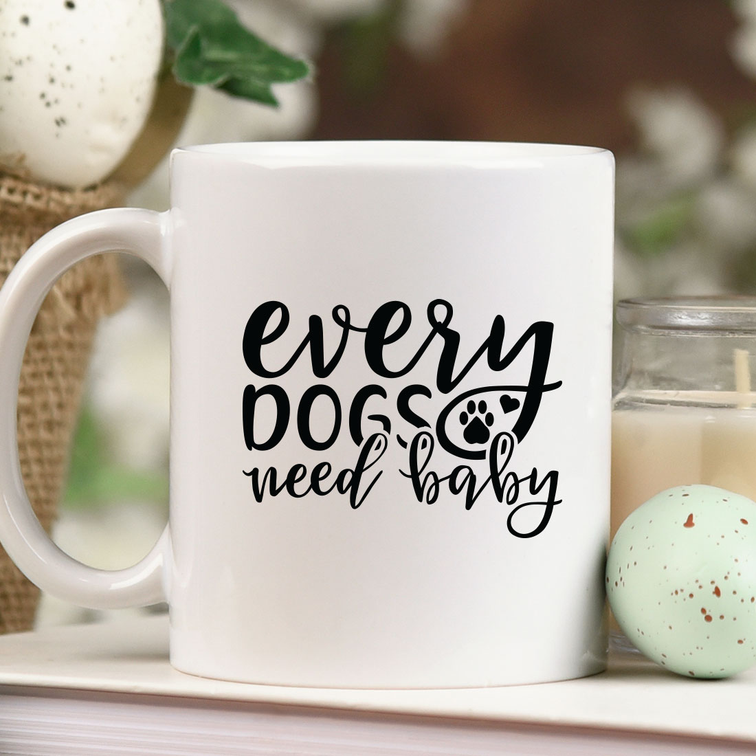 White coffee mug sitting on top of a table next to a candle.