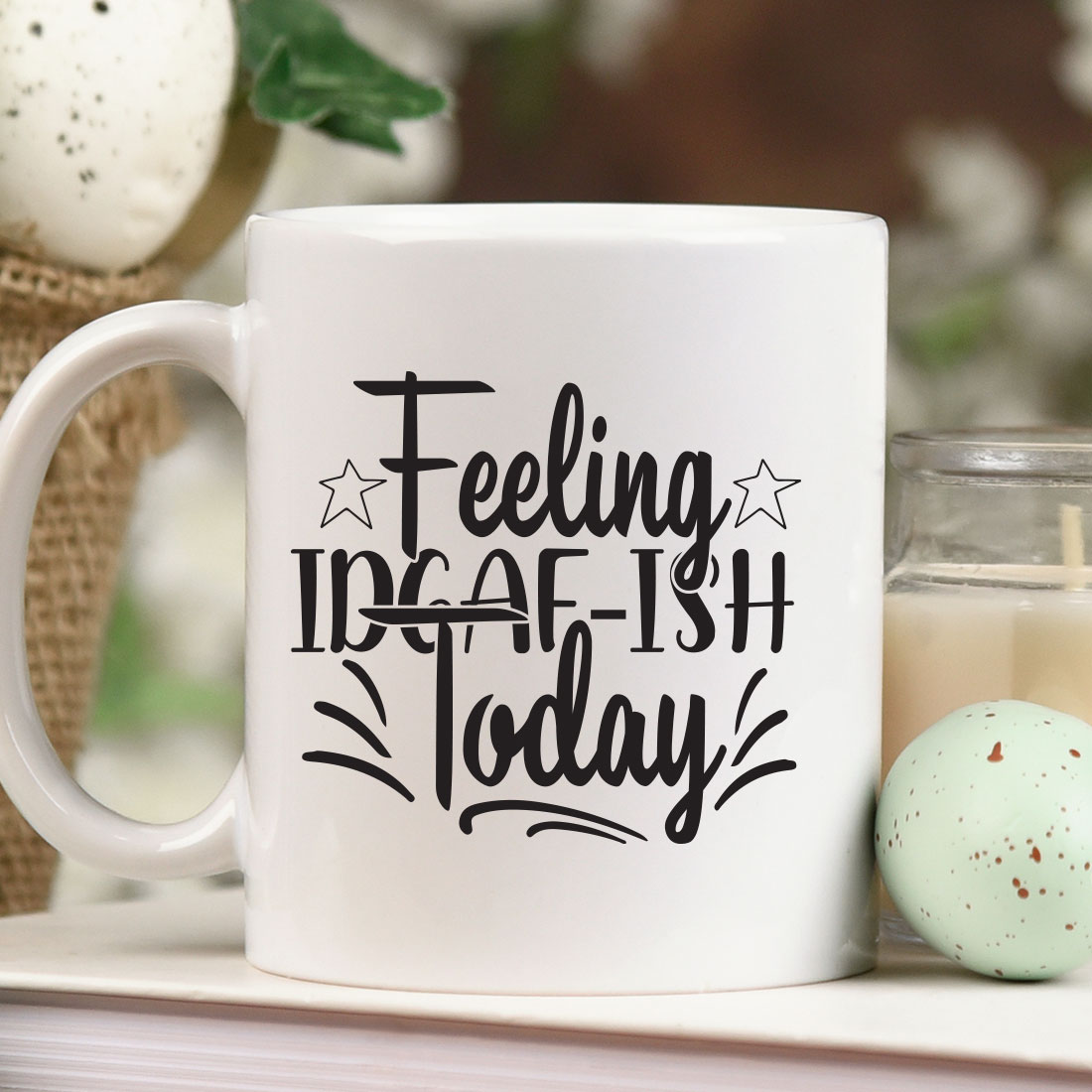 Coffee mug sitting on a table next to a candle.