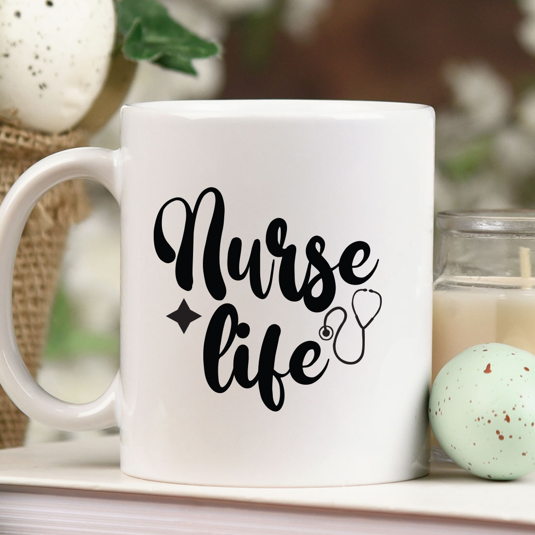 Coffee mug with the words nurse life next to a candle.