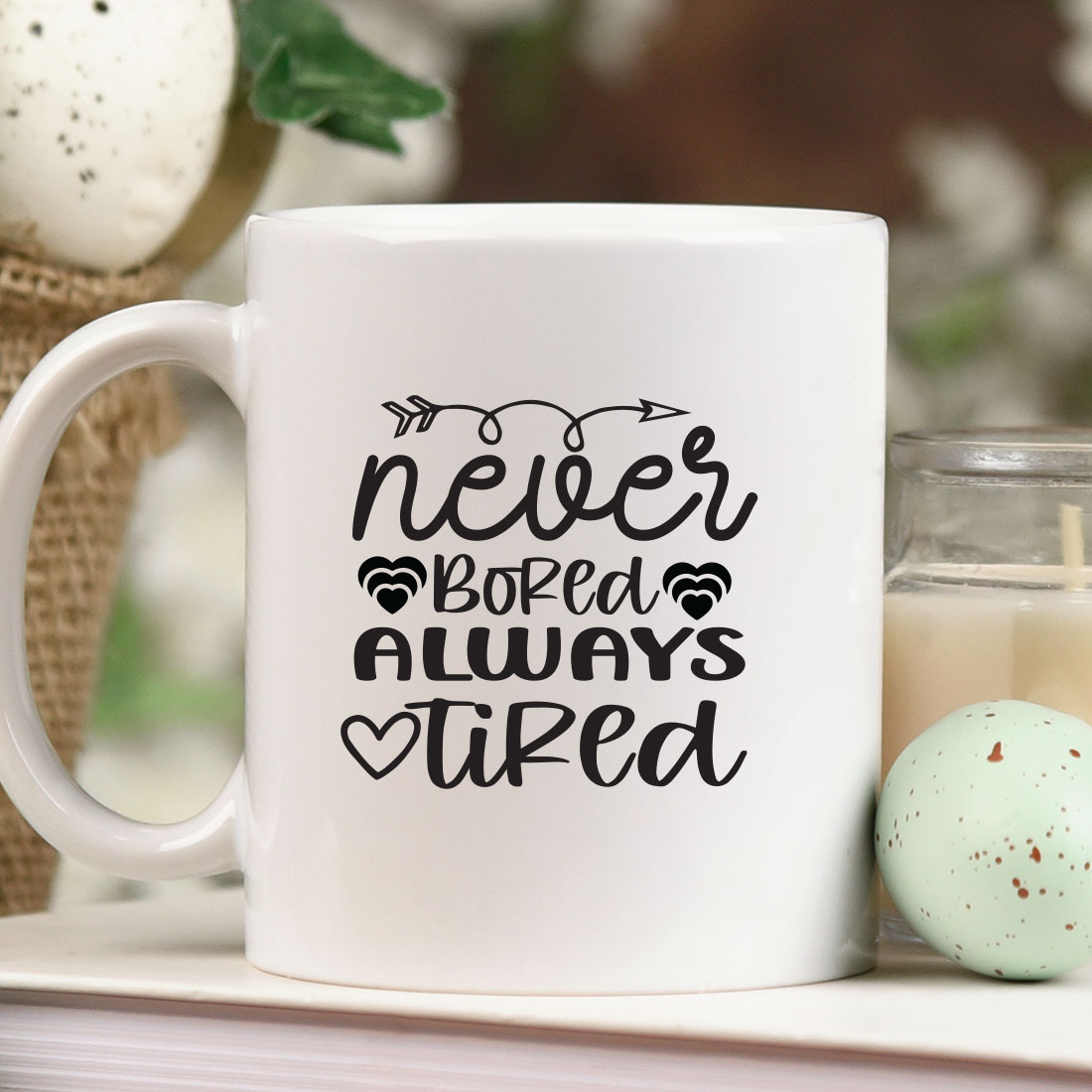 White coffee mug sitting on top of a table next to a candle.