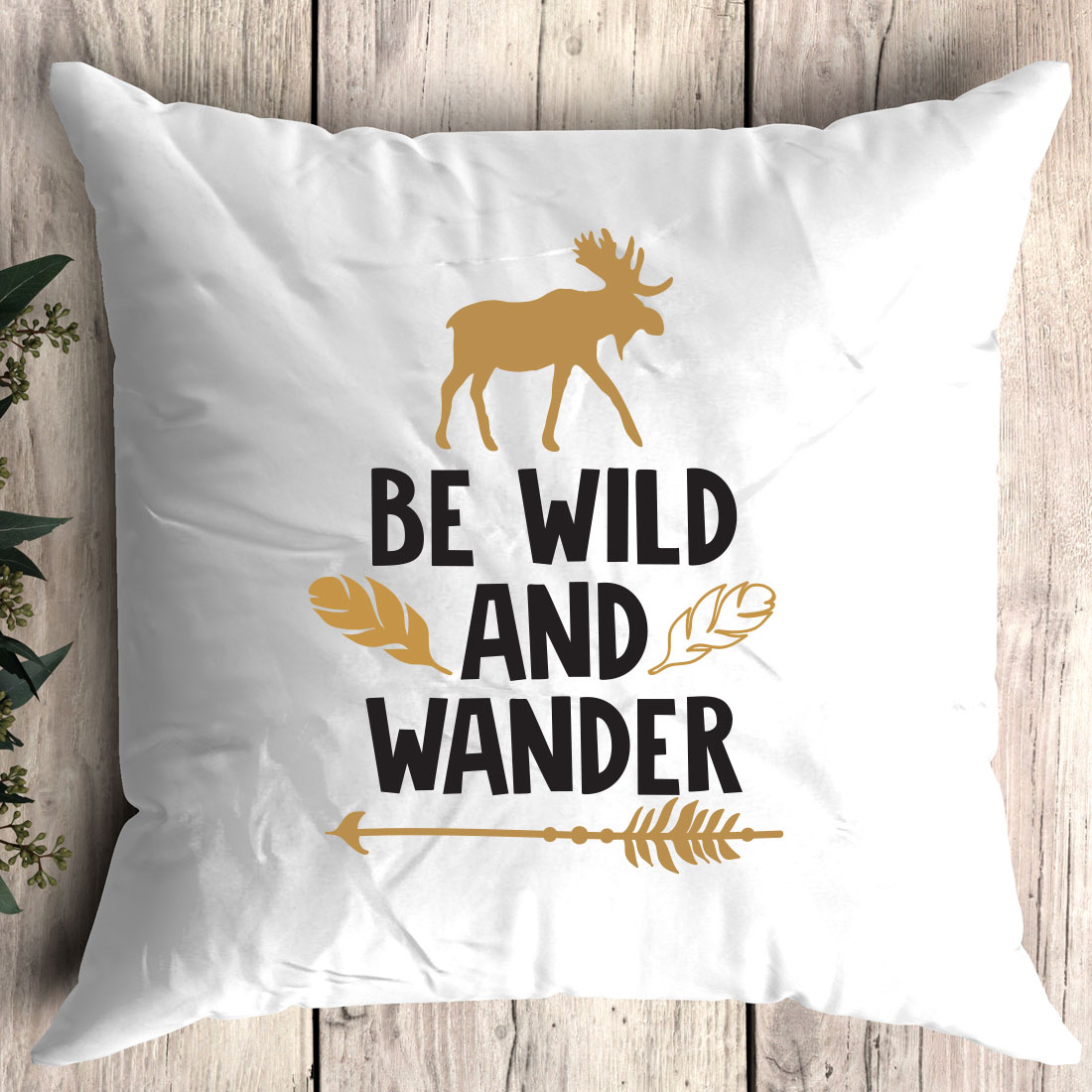 White pillow with the words be wild and wander printed on it.