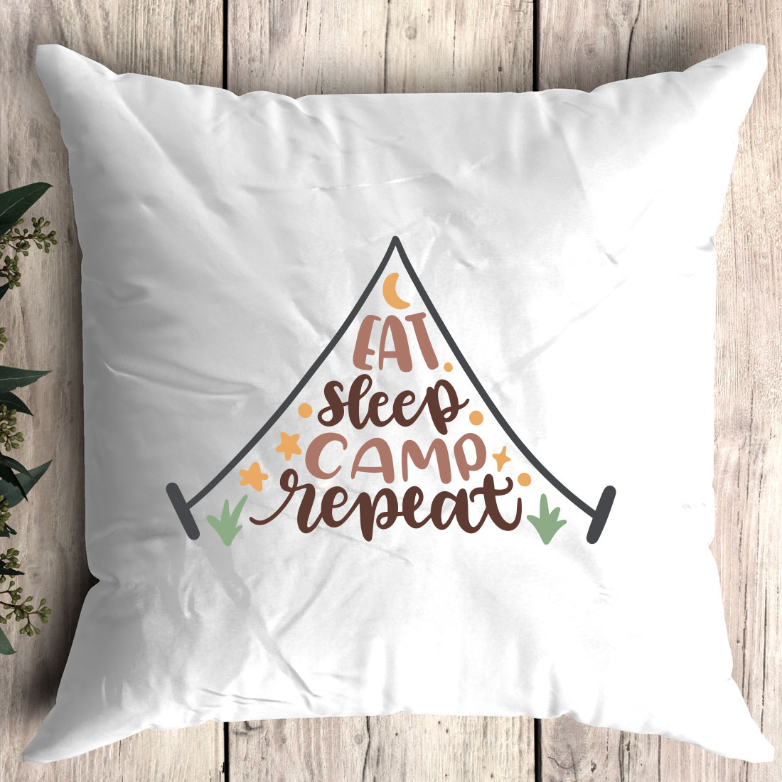 Pillow with the words eat sleep camp repeat on it.