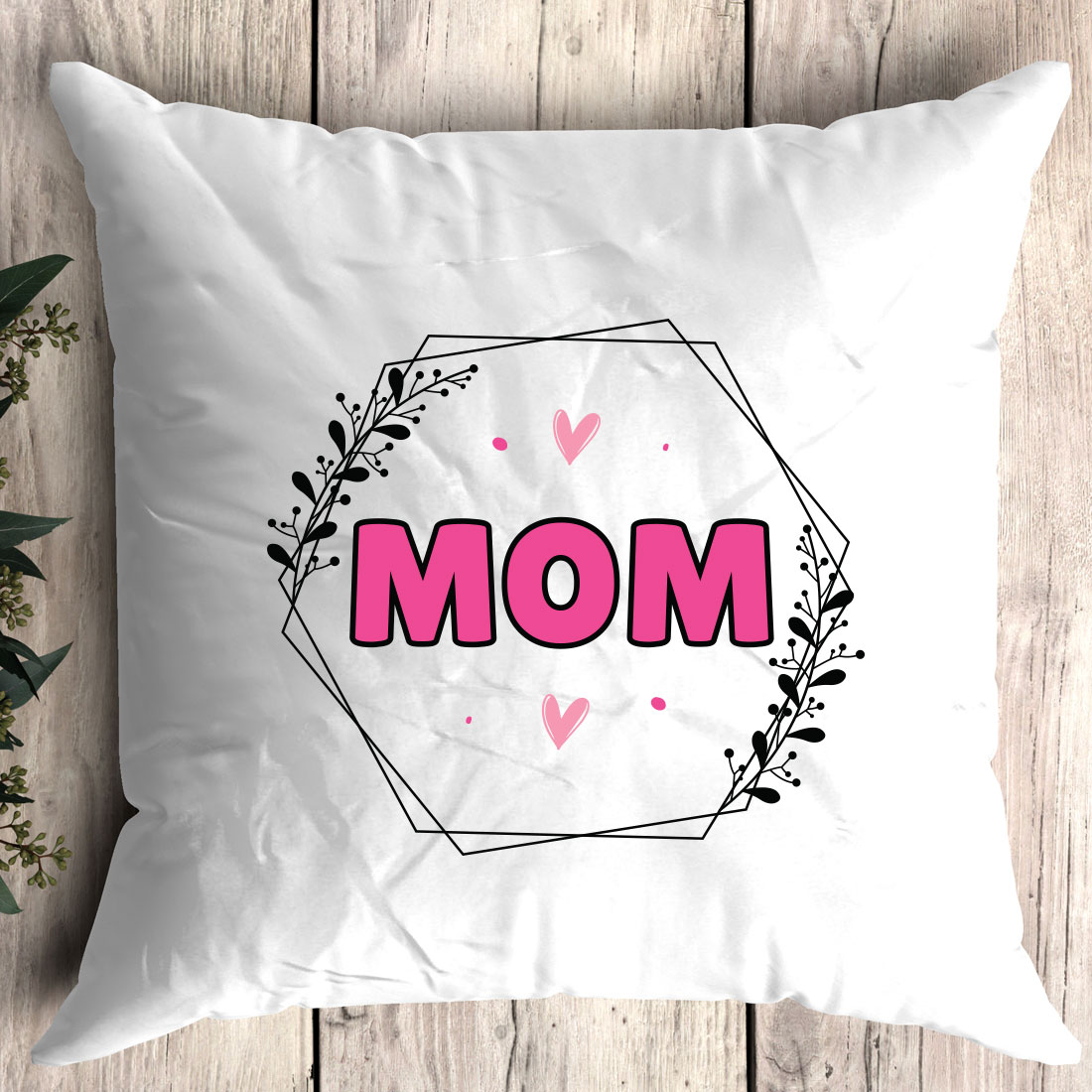 White pillow with the word mom printed on it.