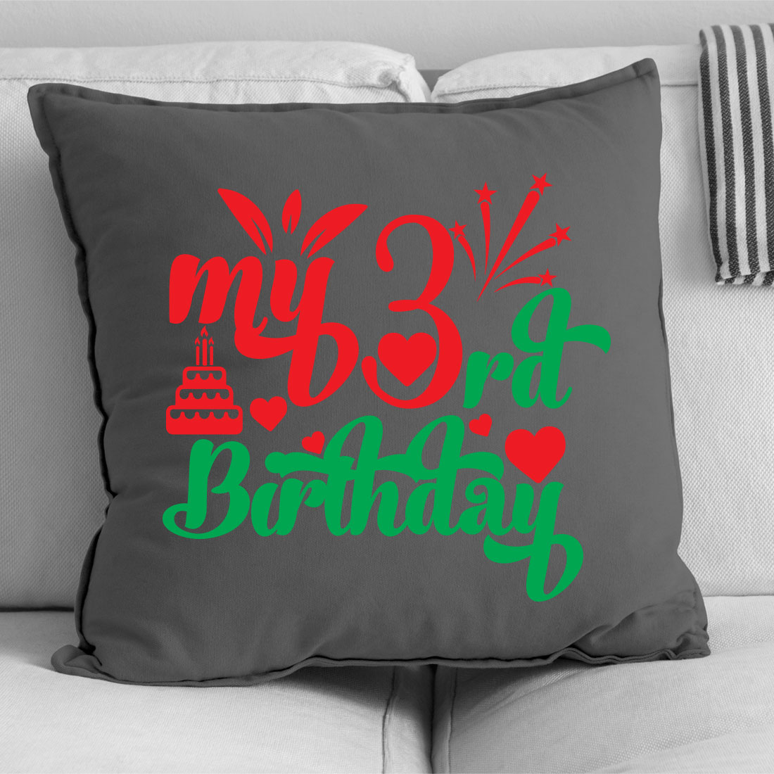 Gray pillow with a red and green design on it.