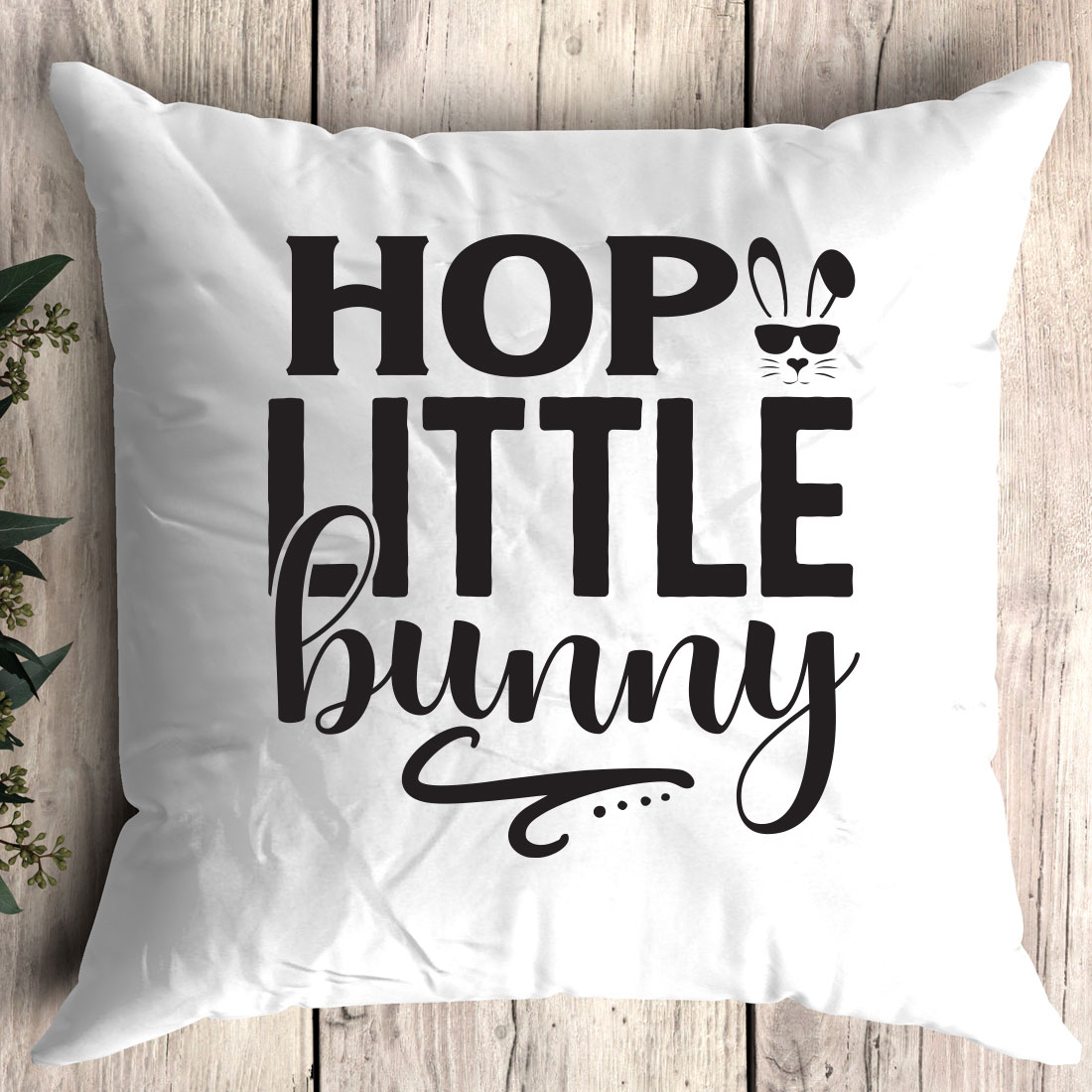 White pillow with the words hop little bunny on it.