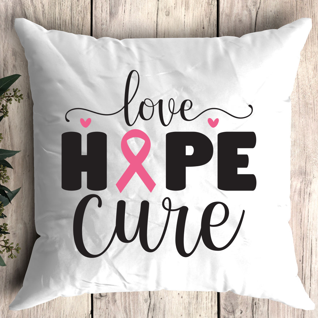 White pillow with a pink ribbon on it.