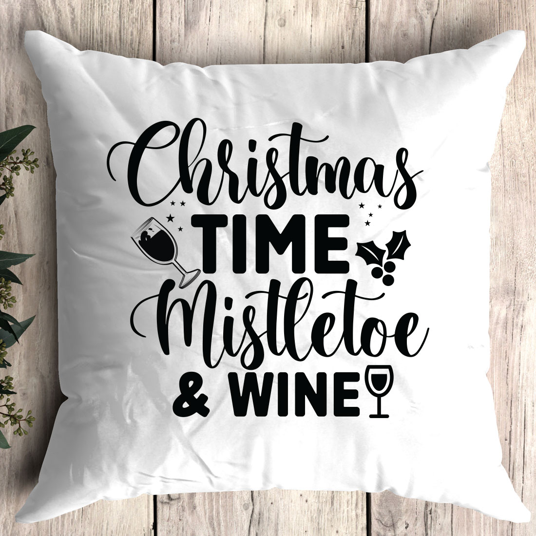 White pillow that says christmas time mistle and wine.