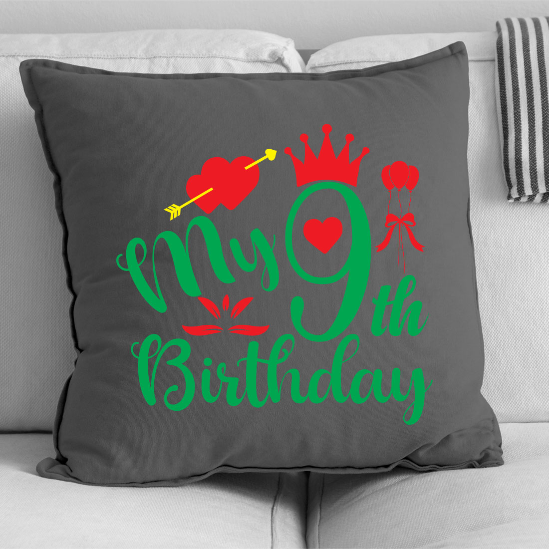 Gray pillow with a green and red design on it.