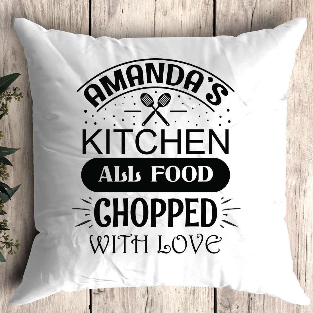 White pillow that says amanda's kitchen all food chopped with love.