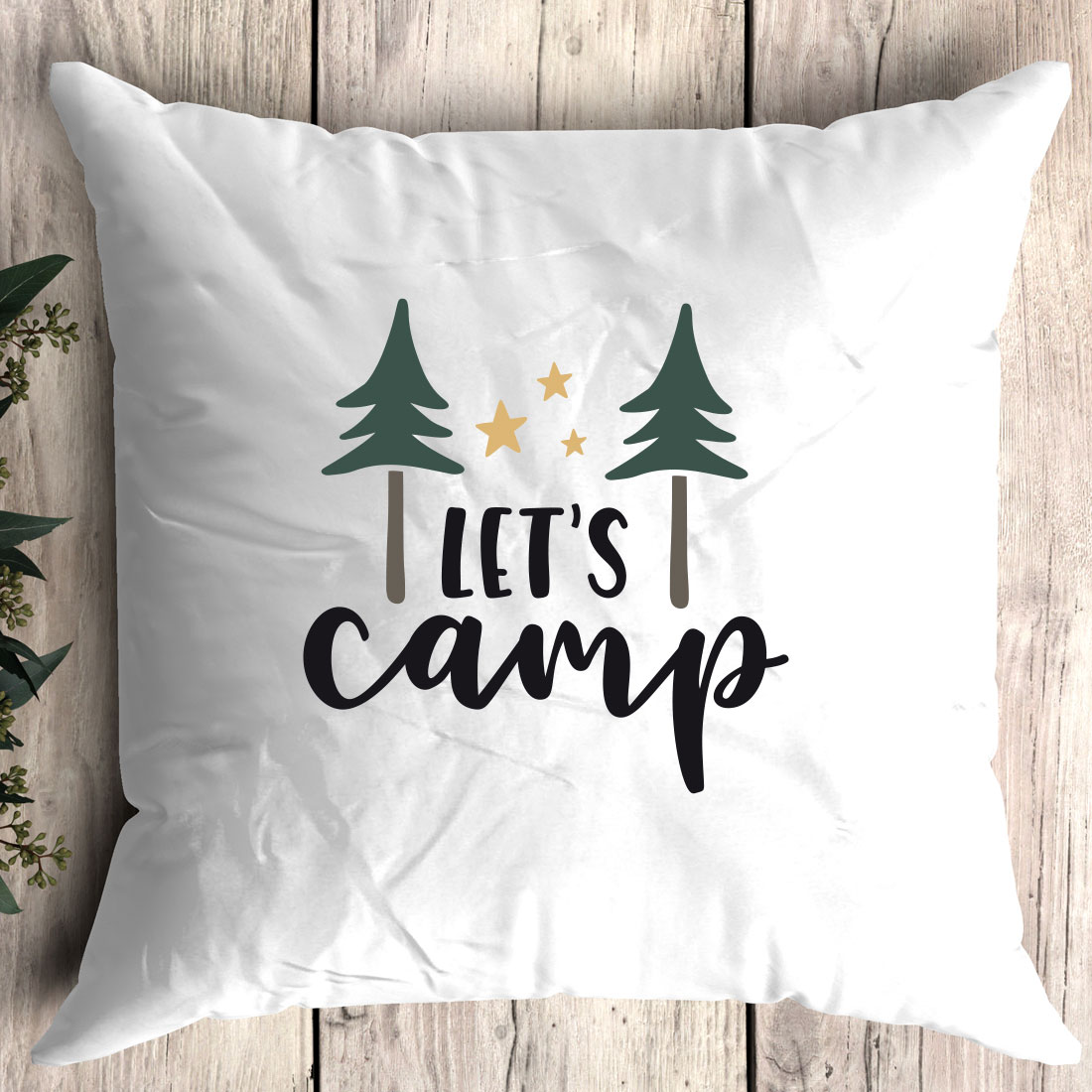 White pillow with the words let's camp printed on it.