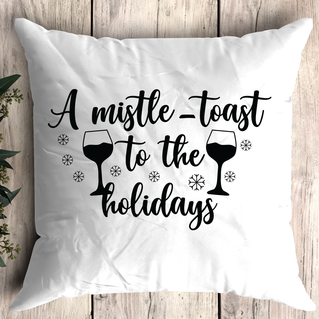 White pillow that says a mistle - toast to the holidays.