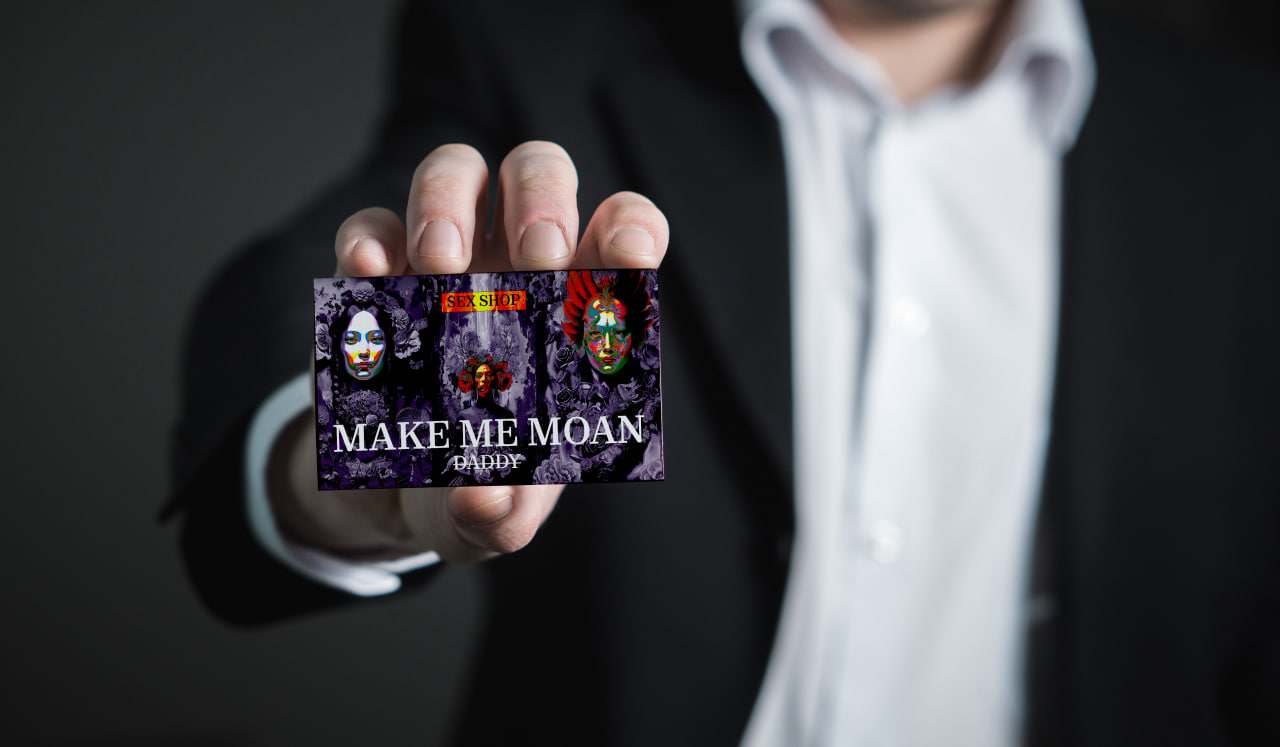 Man in a suit is holding a business card.