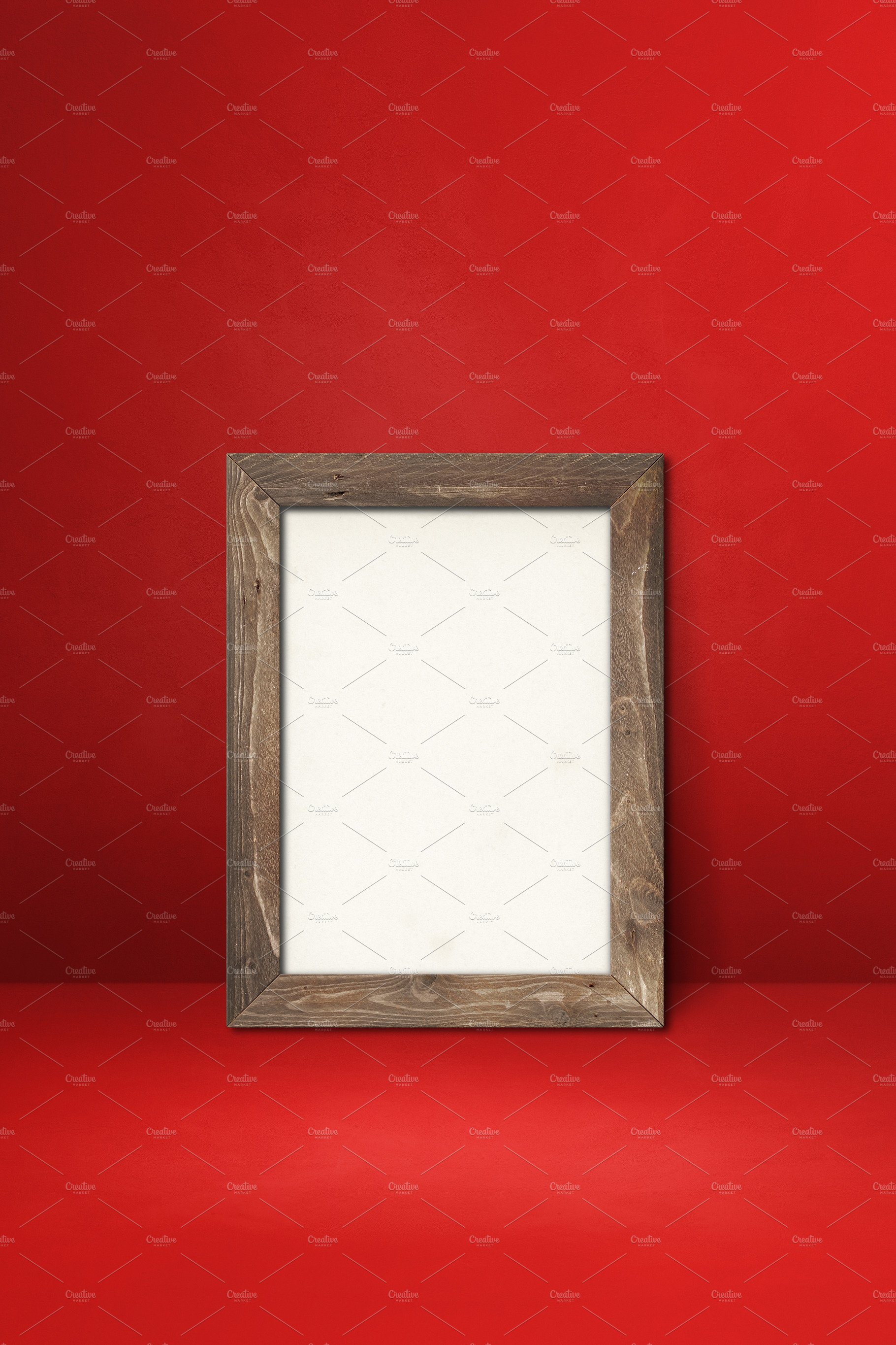 Wooden picture frame leaning on a red wall cover image.