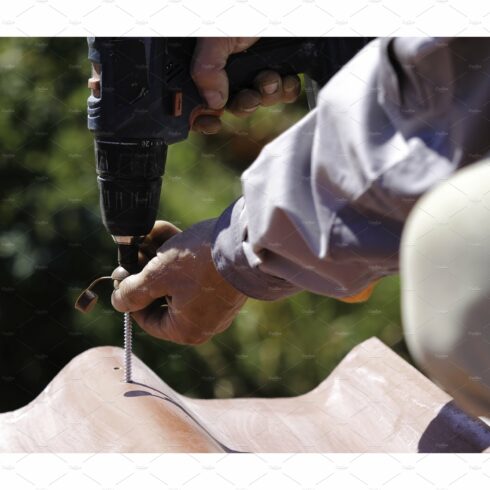 Man screws a screw into the roof cover image.