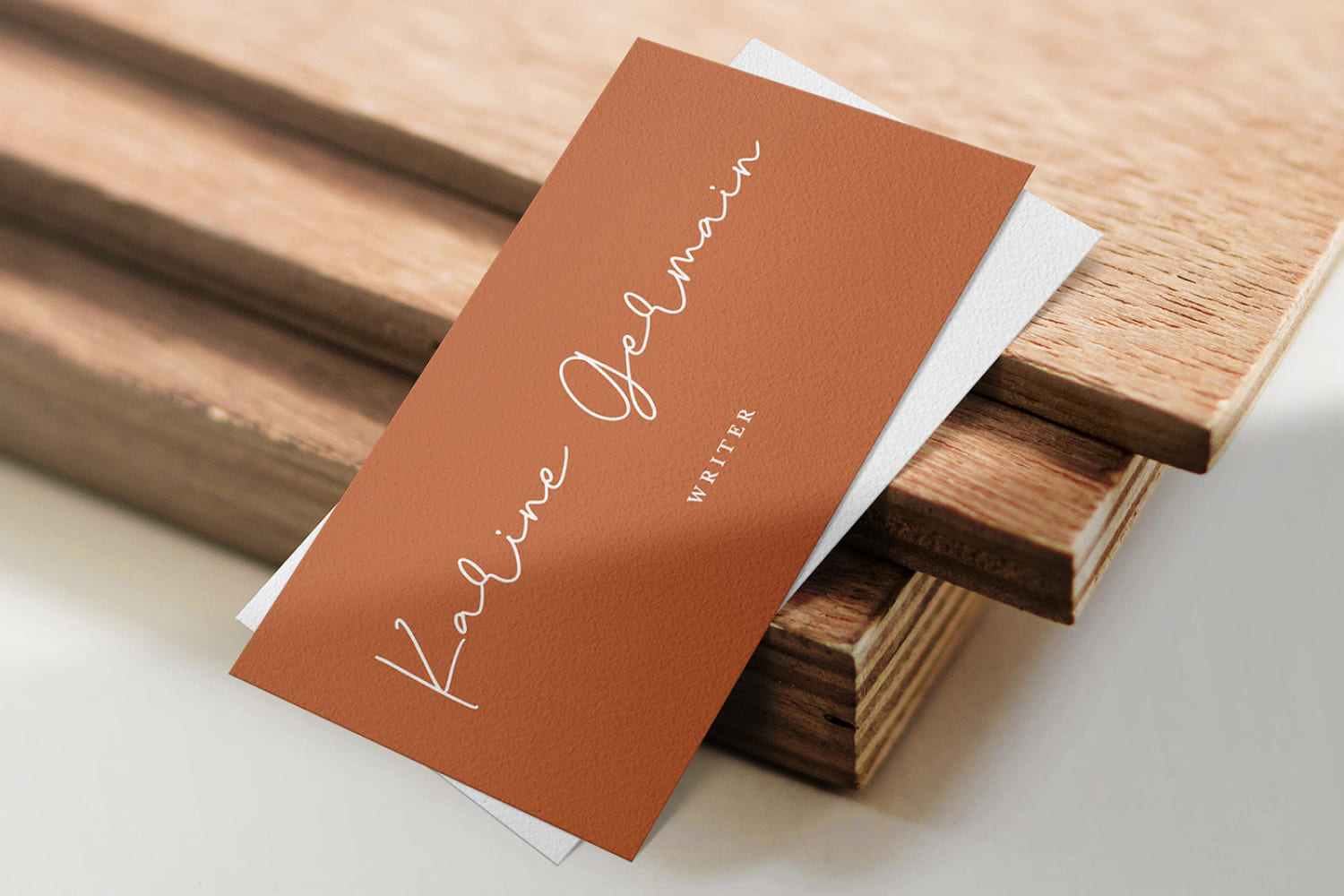 Photo of a brown business card on the background of boards and handwritten text.