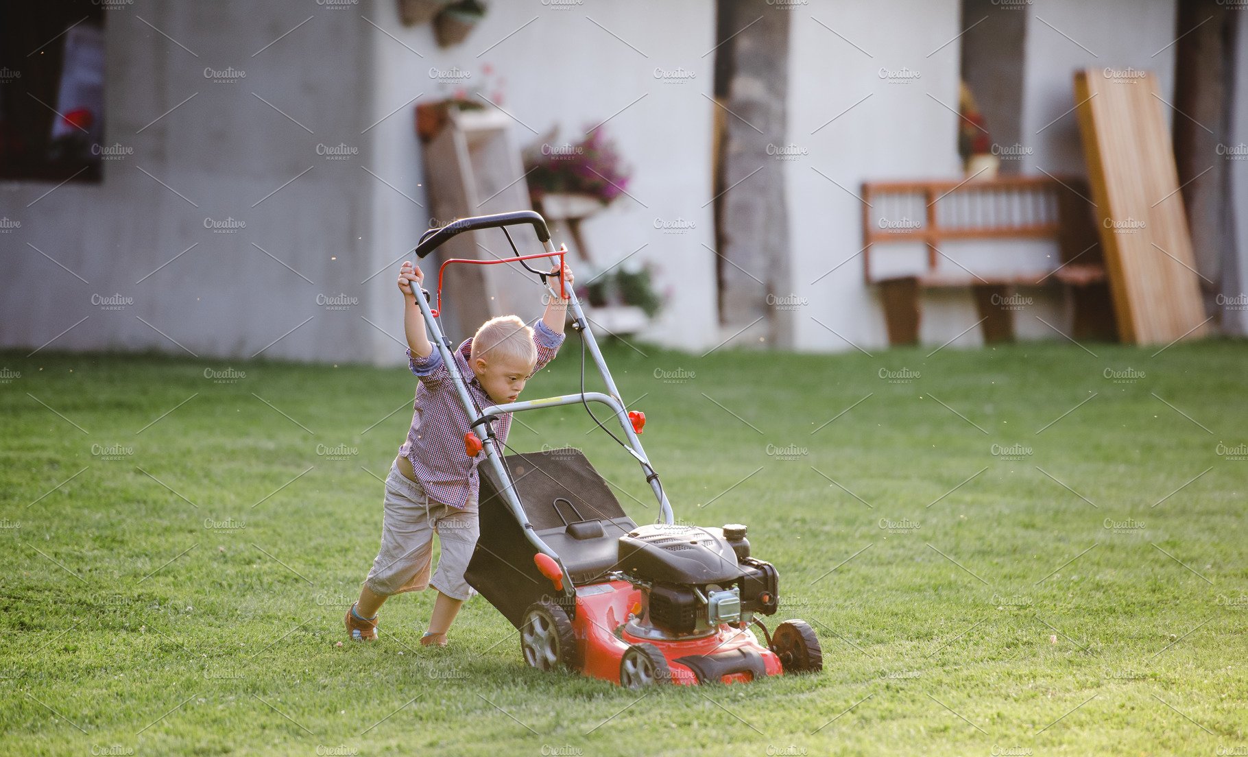 Down syndrome child with lawn mower cover image.