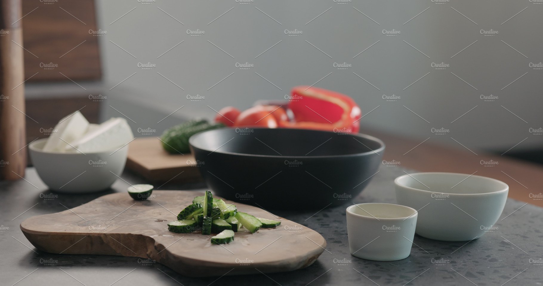 Man chopping cucumber on olive wood cover image.