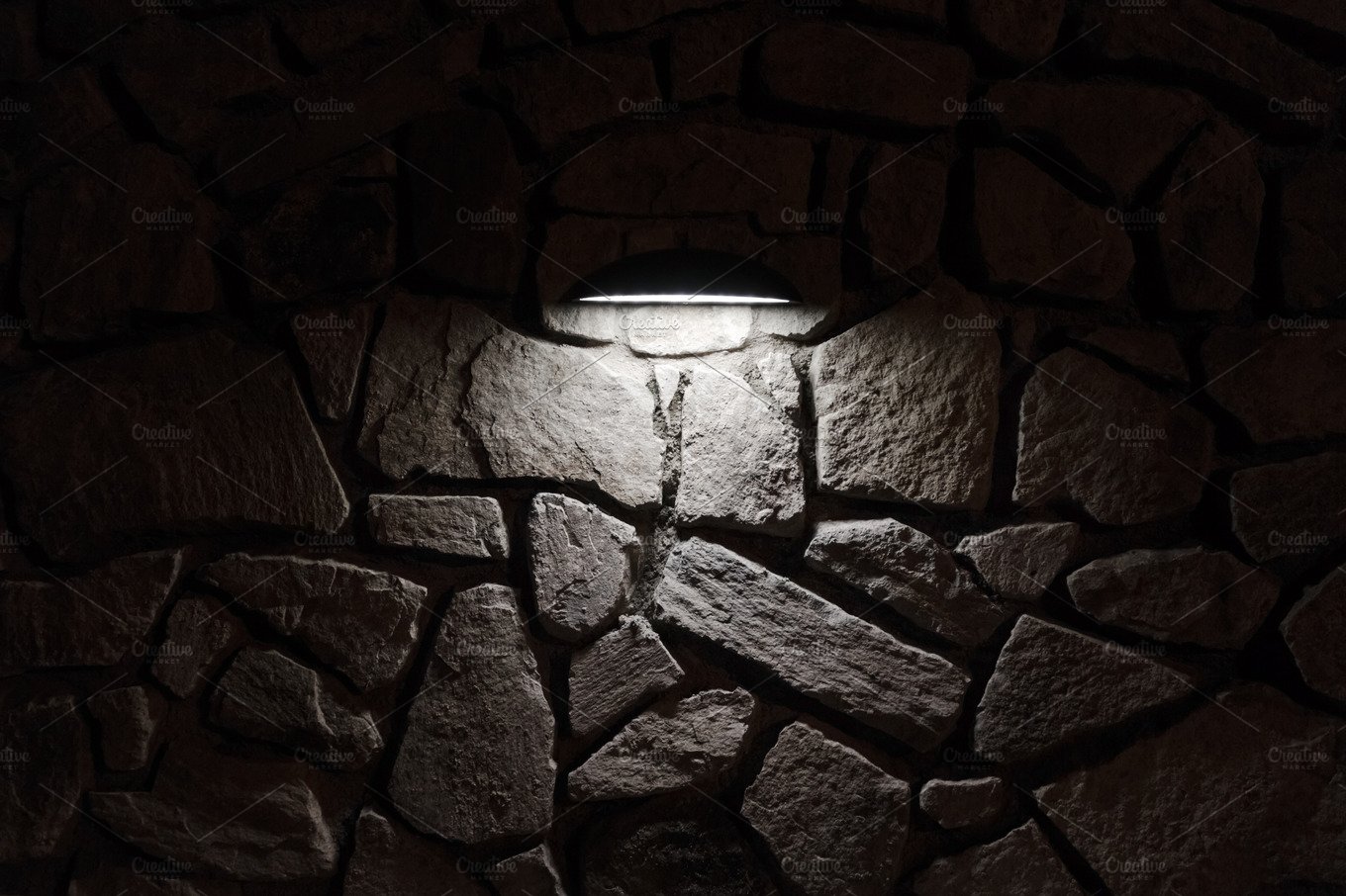 Lamp casting light on stone wall cover image.