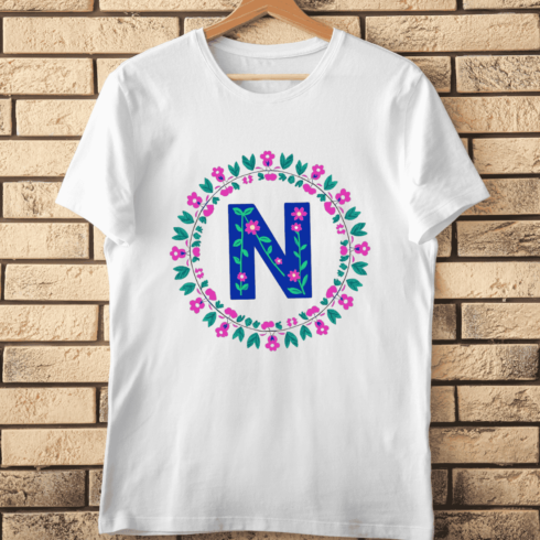 Hand-Drawn Style N in Floral Round Frame T-Shirt Design cover image.