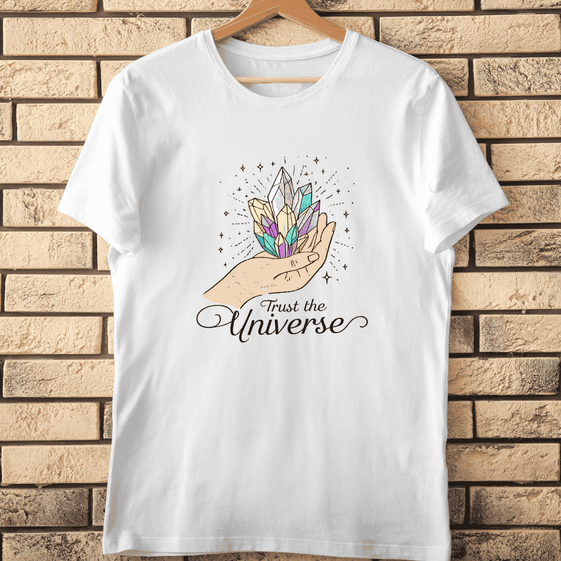 Hand Holding Colorful Crystals Trust the Universe T-Shirt Design cover image.