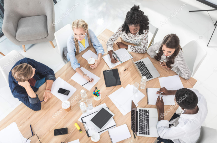 Girls sitting at a table with laptops.