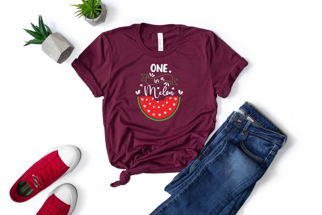 Dark jeans and a burgundy T-shirt with a picture of a watermelon.