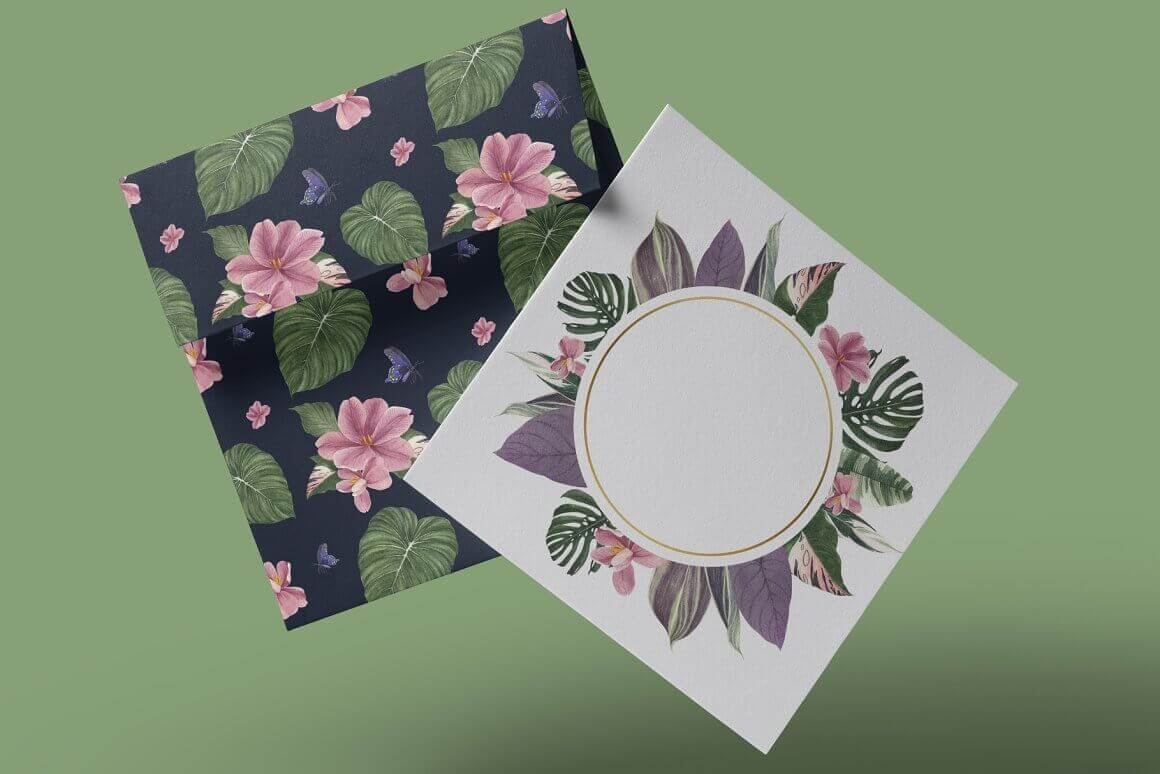 A white postcard with a tropical design lies next to a black envelope with pink flowers and large tropical leaves.
