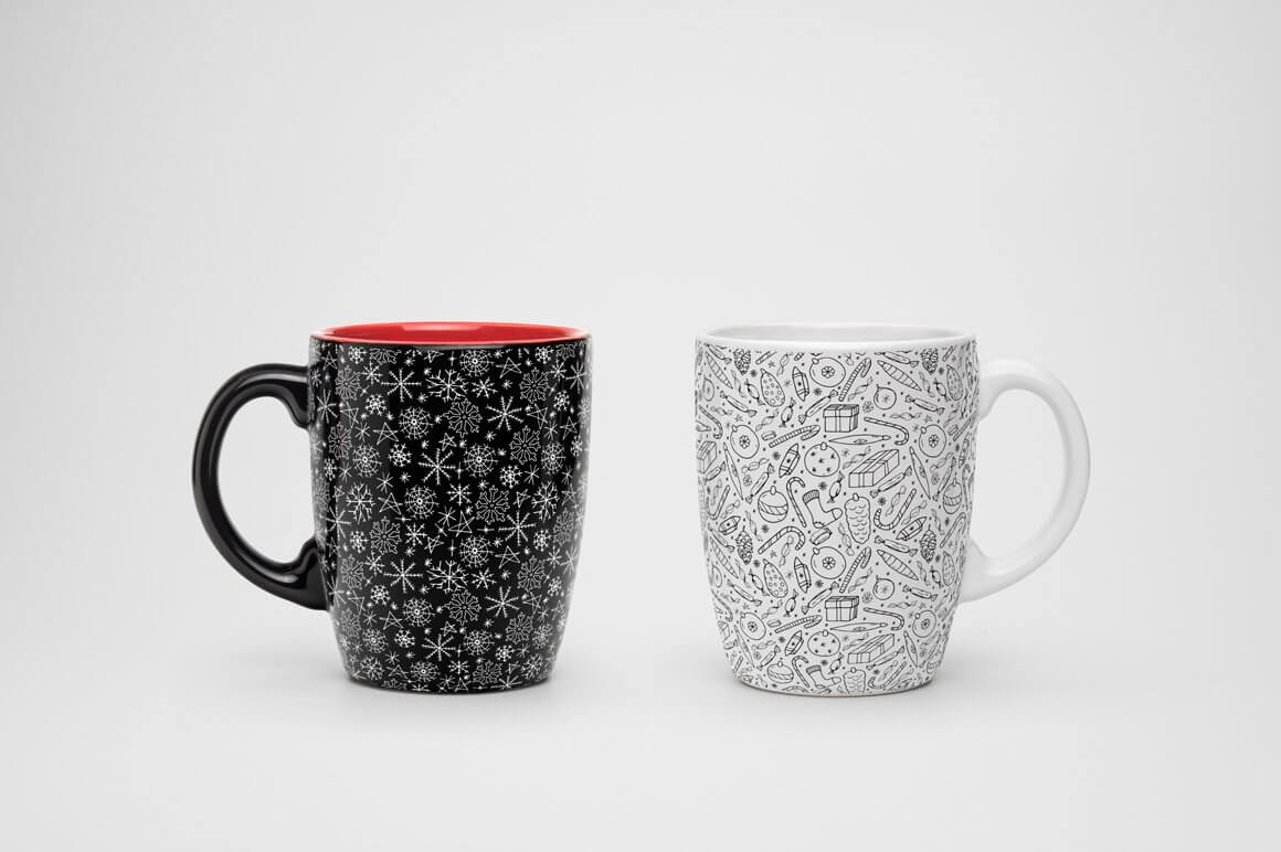 Black cup with white snowflakes, white cup with small black pattern.